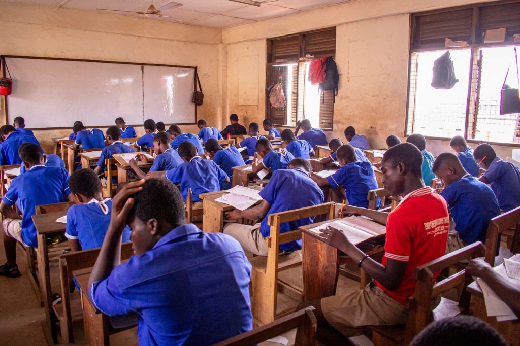 Group of students in a classroom setting taking an exam.